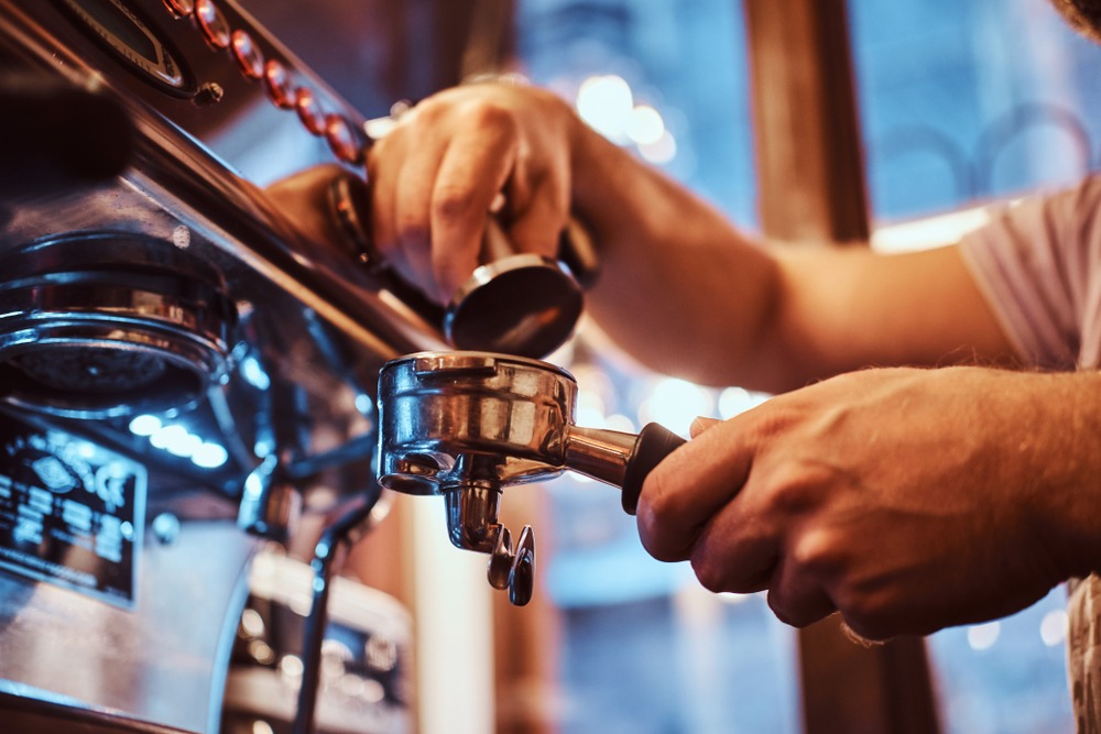 close up,photo,of,a,barista,holding,a,portafilter,with,a