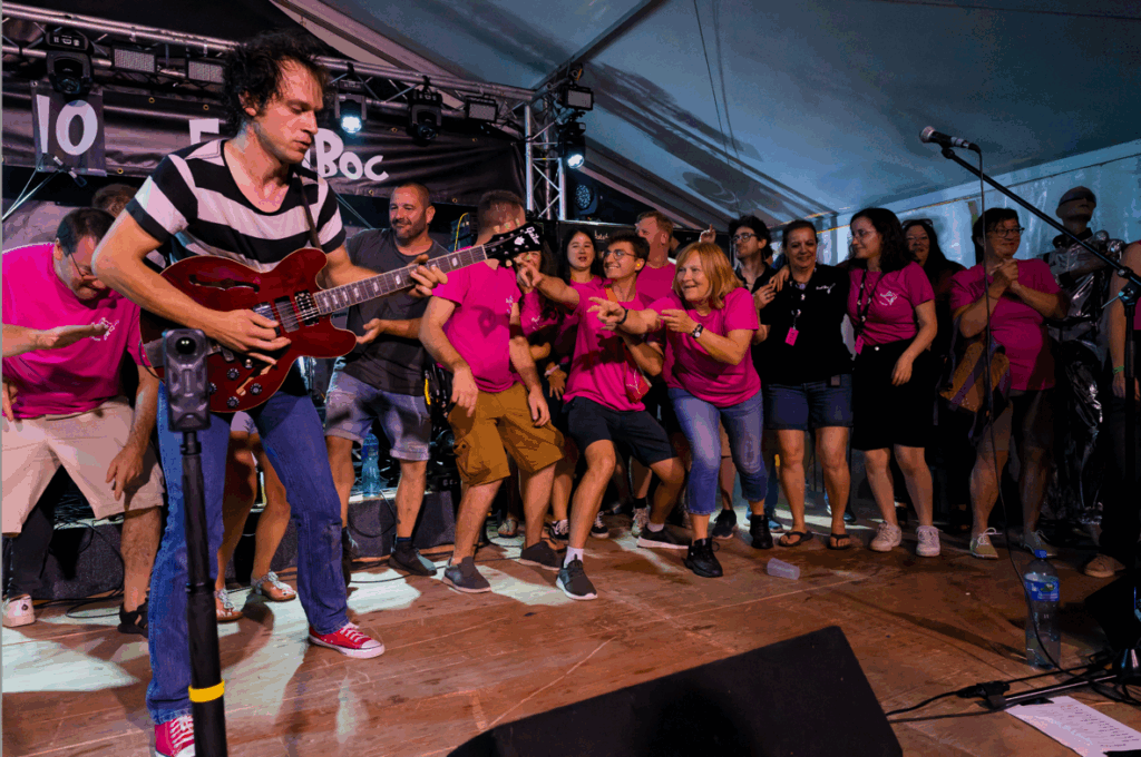 Concert rock avec public enthousiaste sur scène.