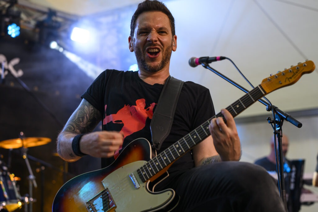 Guitariste jouant sur scène avec passion.