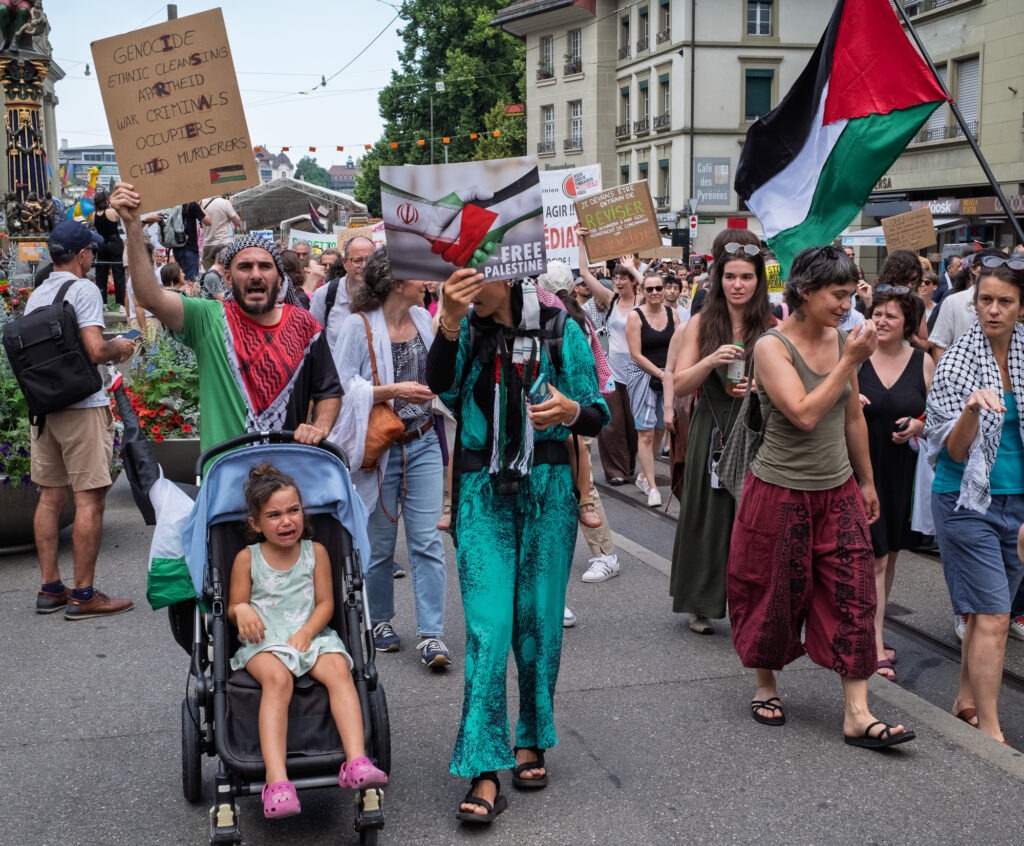 Manifestation avec pancartes et drapeaux.