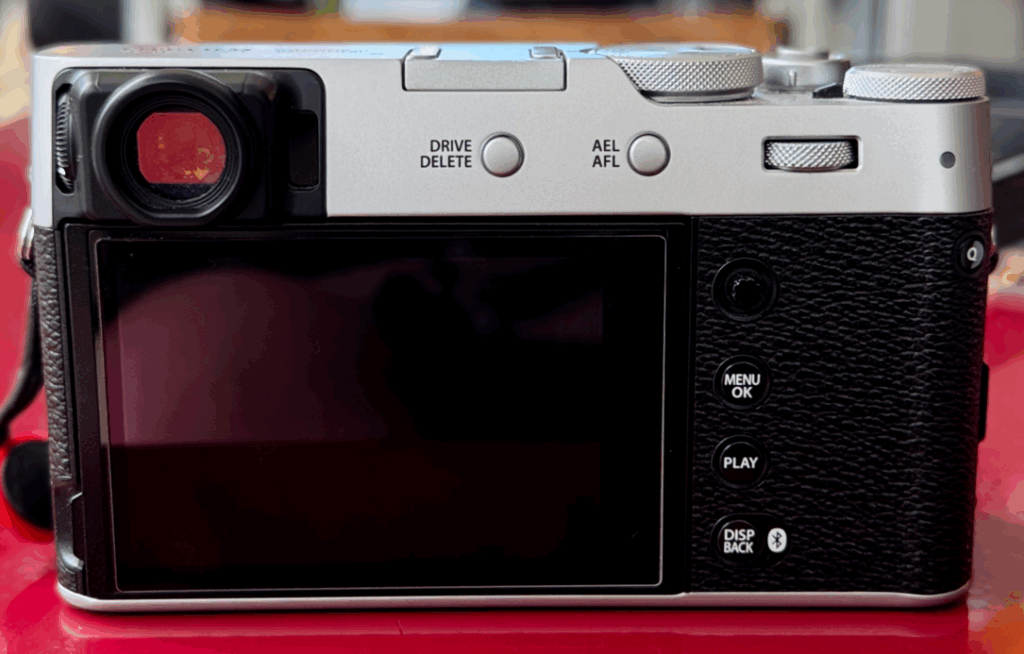 Appareil photo argentique avec écran arrière et boutons.