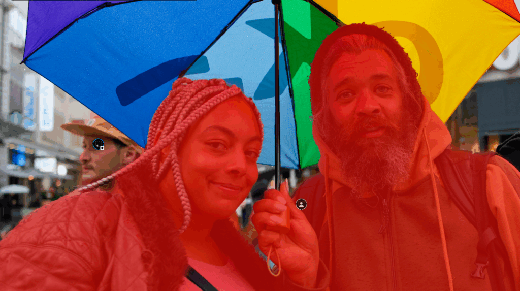 Deux personnes sous un parapluie coloré.