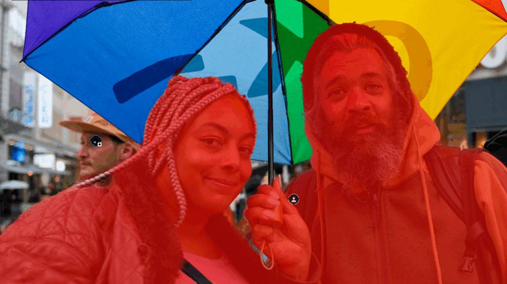 Deux personnes sous un parapluie coloré.