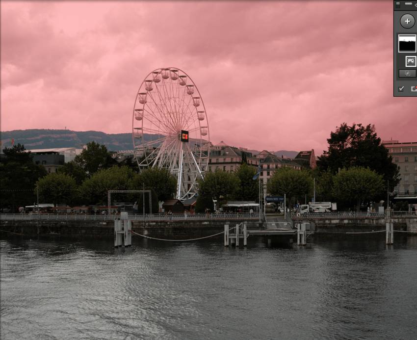 Grande roue au bord du lac, ciel rose.