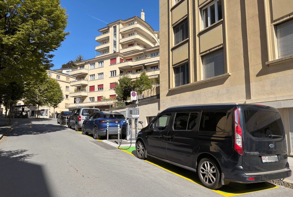 Ruelle avec voitures stationnées devant des immeubles modernes.