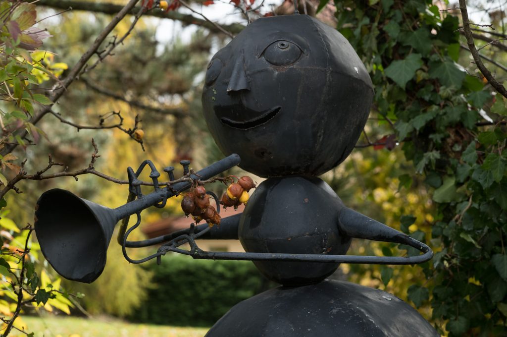 Sculpture métallique d'un personnage jouant de la trompette.