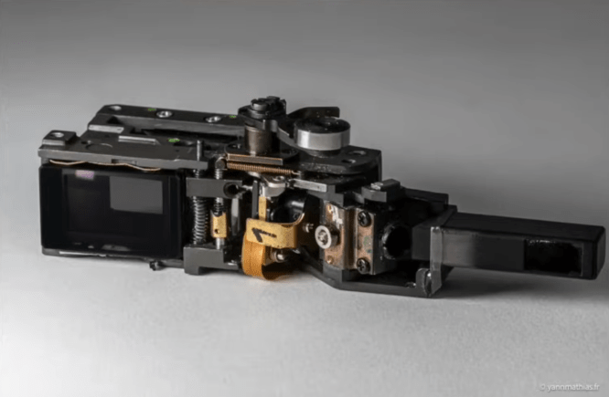 Appareil photo numérique démonté sur fond gris.