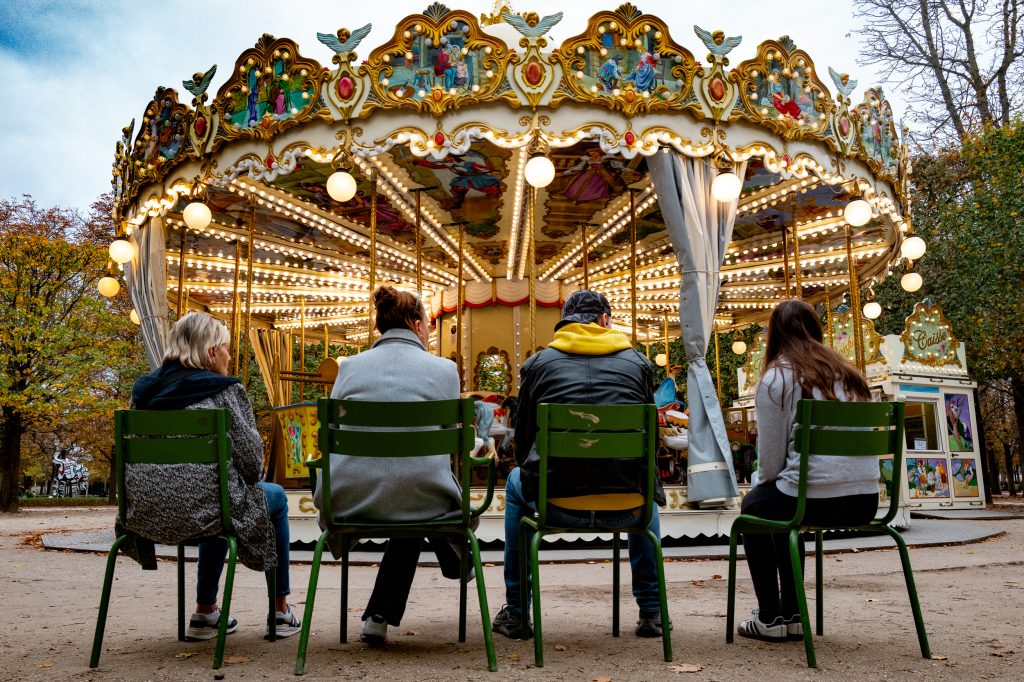 Personnes assises devant un manège éclairé.