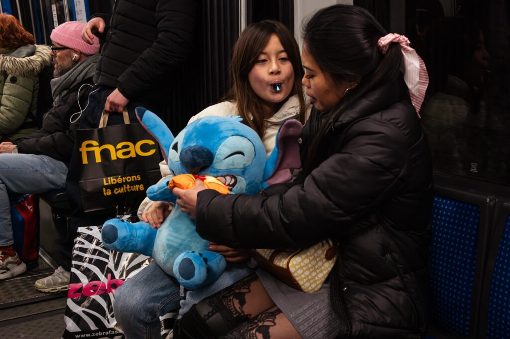 Enfants avec peluche bleue dans le métro.