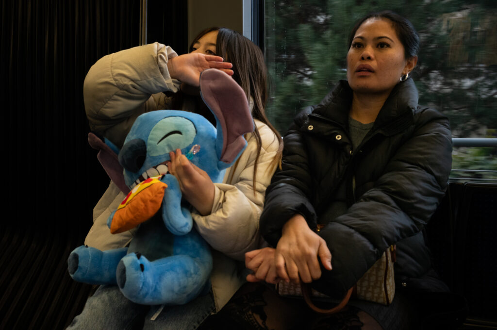 Deux femmes assises avec une peluche Stitch.