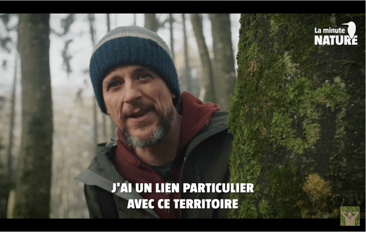 Homme dans une forêt avec mousse sur arbre.
