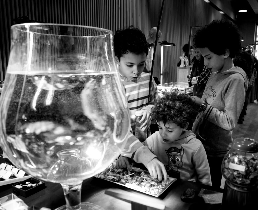 Enfants jouant derrière un grand verre