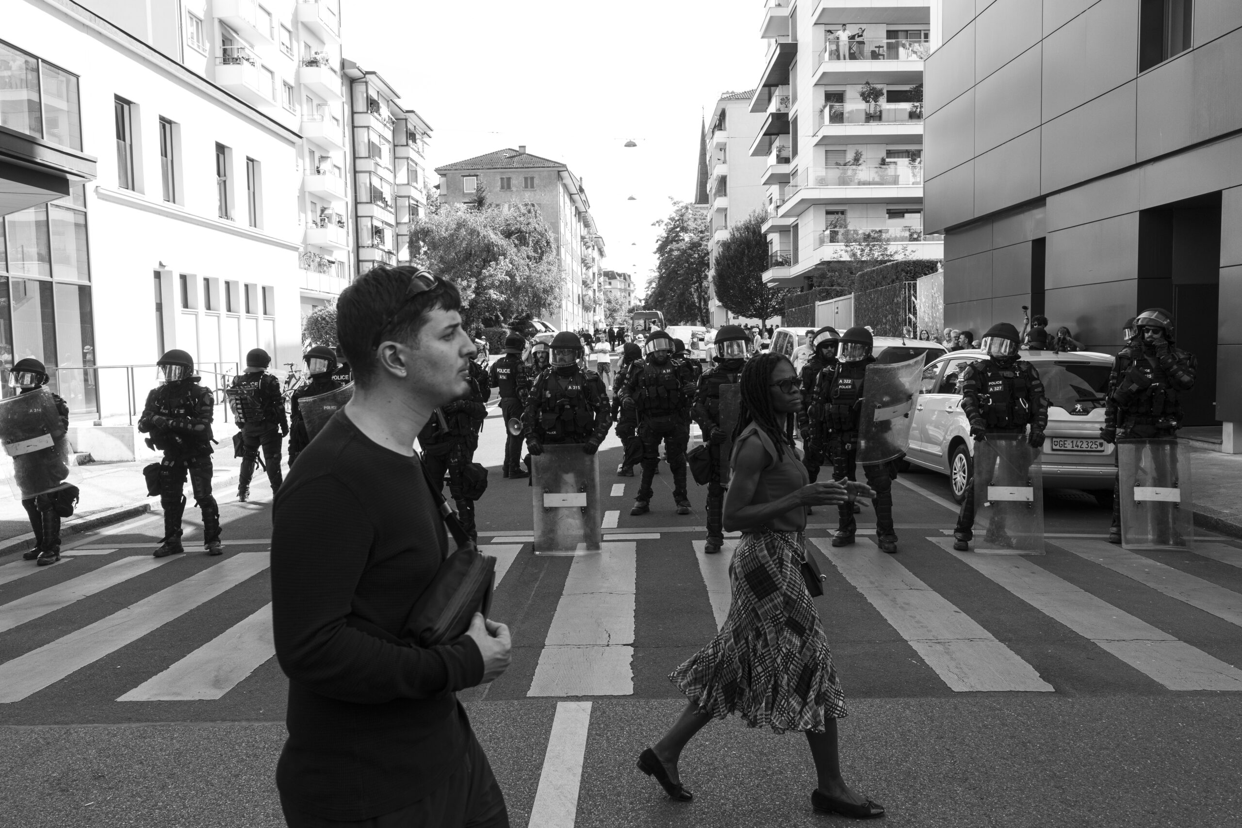Ligne de policiers antiémeute bloquant une rue urbaine
