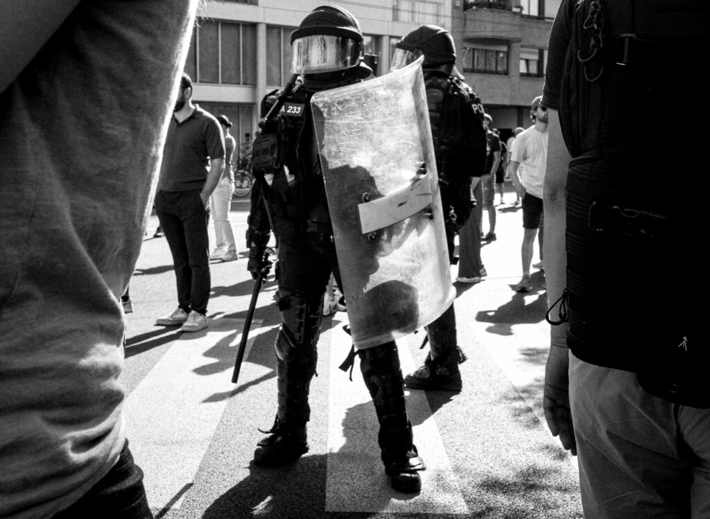 Policiers antiémeutes en tenue face à des civils
