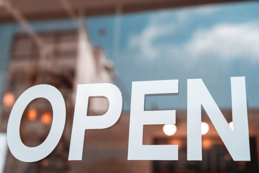 open,sign,broad,through,the,glass,of,door,in,cafe.