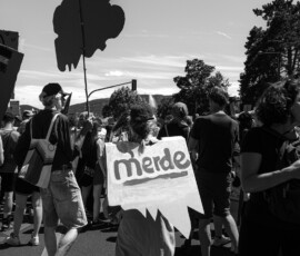 Manifestation de rue avec pancarte contestataire en noir et blanc