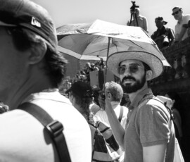Homme barbu au chapeau tenant un parapluie