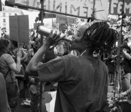 Manifestante buvant de l’eau lors d’un rassemblement féministe