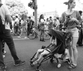 Foule urbaine avec mère et poussette d’enfants